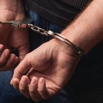 Close up of male hands in bracelets behind back