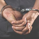 prisionero-pie-esposado-manos-detras-espalda_109549-66
