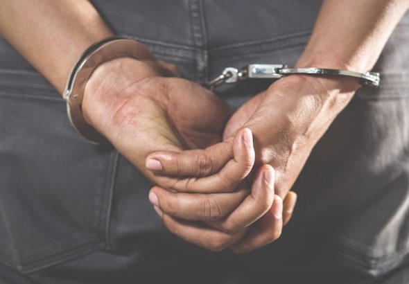 prisionero-pie-esposado-manos-detras-espalda_109549-66