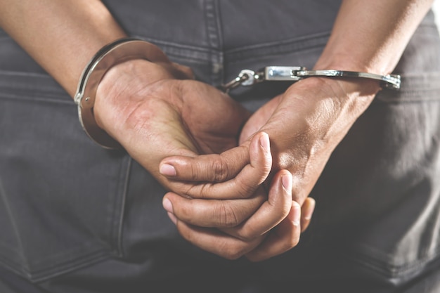 prisionero-pie-esposado-manos-detras-espalda_109549-66